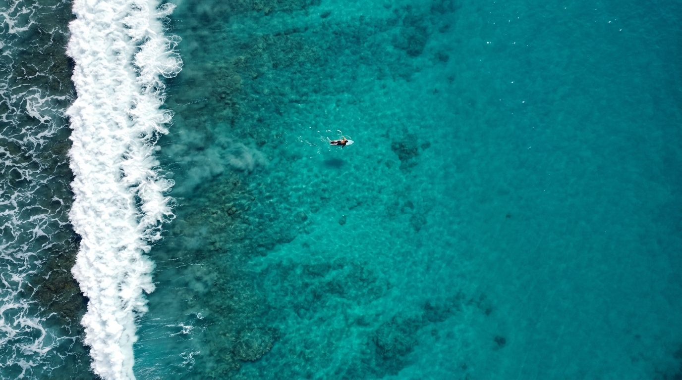 Aerial ocean wave in Gerupuk Bay with surfer